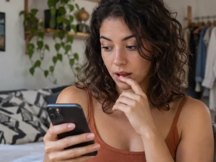 Mulher pausa antes de confirmar uma ação no celular