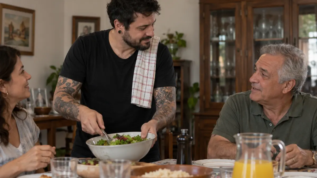 Homem tatuado serve salada enquanto conversa com familiares à mesa